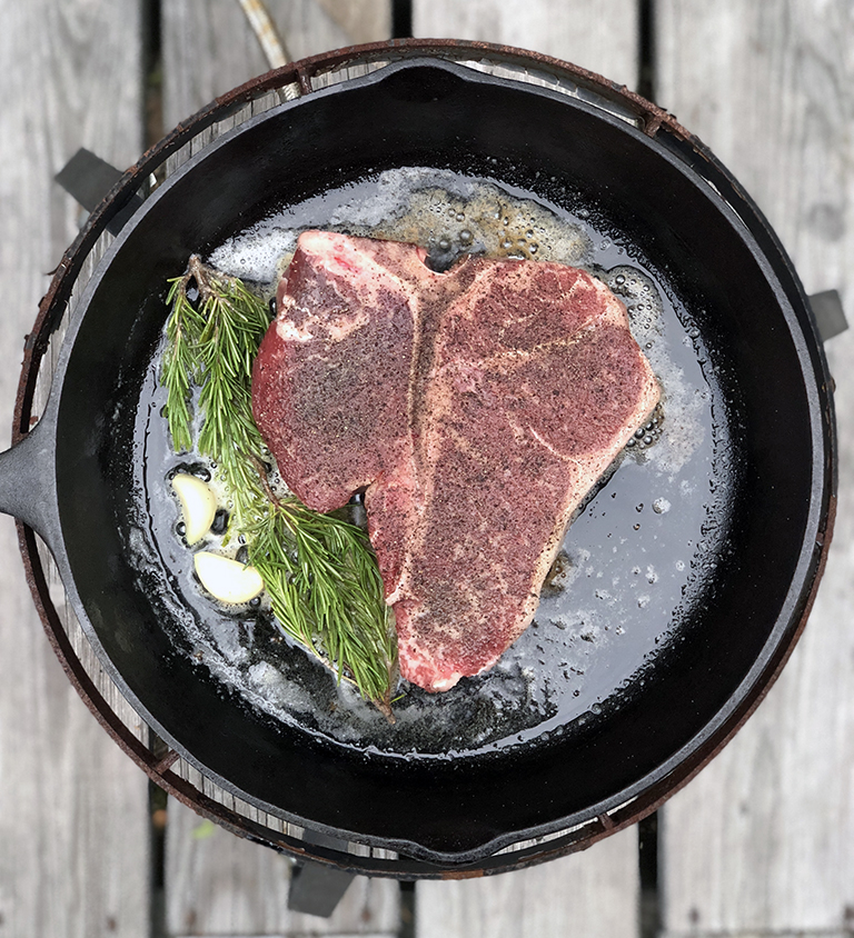 cooking a steak in a cast iron skillet - photo by Bob Borson